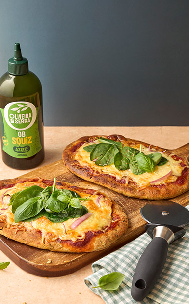 Pizza de pão naan com cebola roxa e espinafres